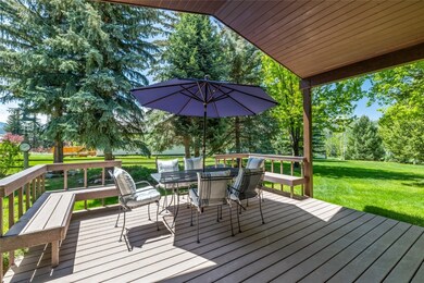 Wooden terrace with outdoor dining space, a yard,