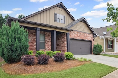 Craftsman house featuring board and batten siding, brick siding, driveway, a garage, and a porch