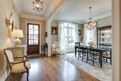 Upon entering, you are greeted by this welcoming foyer with 12 ' ceilings and beautiful crown molding.