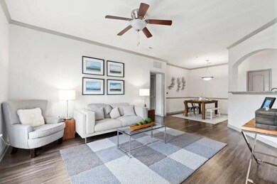 Living room with ceiling fan, ornamental molding, 