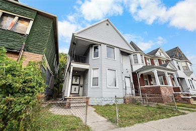 View of front of property featuring a fenced front yard, a gate, and a balcony