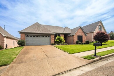 View of front of house featuring brick siding, driveway, a shingled roof, a front yard, and a garage