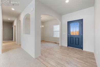 Entryway with recessed lighting, light wood-style flooring, and a chandelier