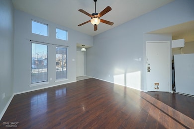 Spare room with a high ceiling, ceiling fan, and hardwood / wood-style floors