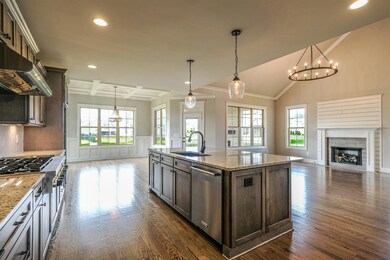 Chef's kitchen offers granite countertops, stainless appliances, and a large island.
