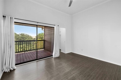 Large primary bedroom with vaulted ceilings, a private balcony, and walk-in closet.