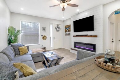 Tiled living room featuring a fireplace and ceilin