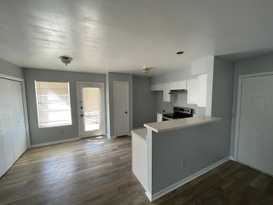 Kitchen featuring electric range, white cabinets,