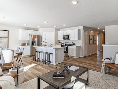 View of dining area and modern kitchen from the living room.  Model home shown.