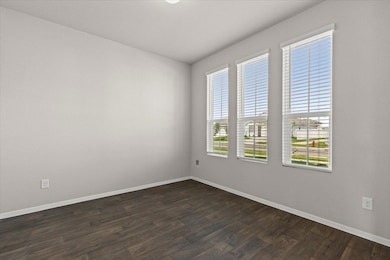 Empty room featuring baseboards and dark wood-sty