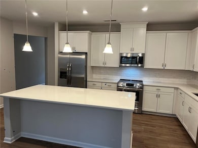 Kitchen featuring stainless steel appliances, white cabinets, and recessed lighting