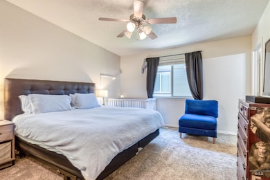 Carpeted bedroom with a textured ceiling and ceiling fan
