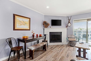Sitting room featuring crown molding, a fireplace, wood finished floors, and recessed lighting