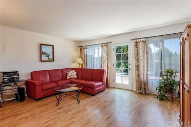 The bright, airy living room has nice wood floorin