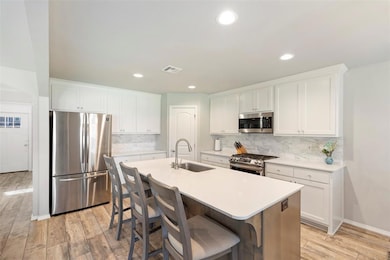 Kitchen with a center island with sink, visible ve