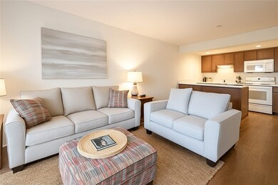 Living room with light wood-style flooring and recessed lighting