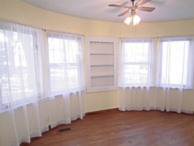 A sunroom/office with newer windows, built-ins, an