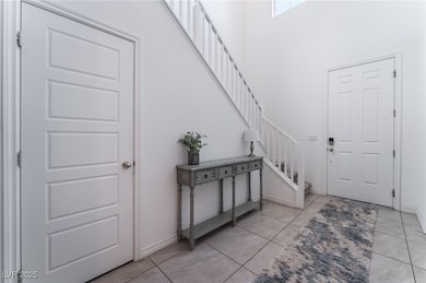 Foyer entrance with stairs, light tile patterned f