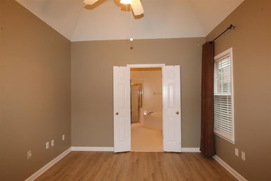 Unfurnished bedroom with wood finished floors, hig