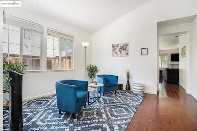 Living area featuring hardwood / wood-style flooring and vaulted ceiling