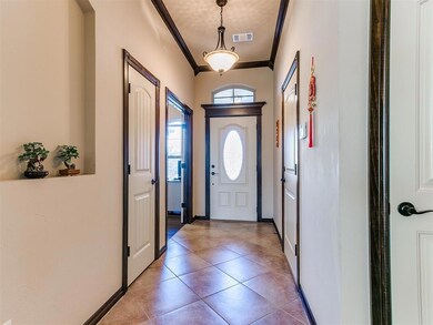 Foyer entrance featuring crown molding and light t