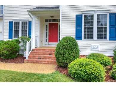 The brightly colored front door has transom and si
