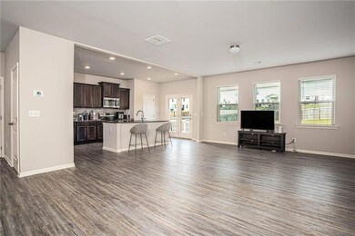 Living area featuring dark wood-style floors, baseboards, and recessed lighting