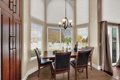 Dining space with plenty of natural light, dark wood-type flooring, and a chandelier