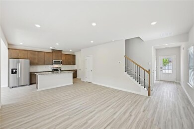 Kitchen with appliances with stainless steel finishes, light wood-style flooring, recessed lighting, a kitchen island with sink, and decorative backsplash