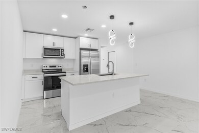 Kitchen featuring white cabinets, sink, an island