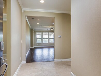 Hall with crown molding and light tile floors
