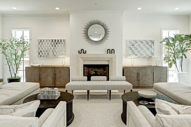 Stunning family room exudes elegance with high ceilings and white oak hardwood floors surrounding the beautiful cast stone gas log fireplace.