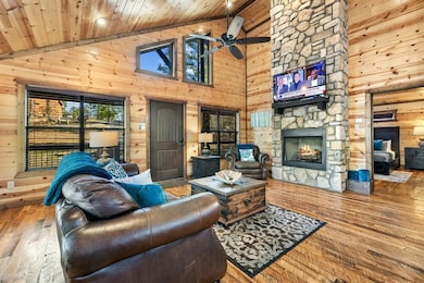 Living room featuring hardwood / wood-style floors, wooden ceiling, a fireplace, and wooden walls