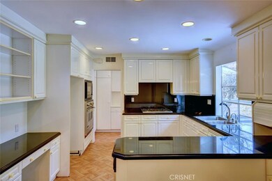 Gas range includes pull out vent hood that matches cabinets and full secretary desk with book shelves