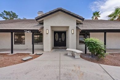 View of exterior entry with stucco siding, a chimney, and a tile roof