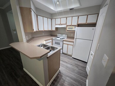 Kitchen featuring white appliances, a sink, under