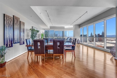 Dining space featuring wood finished floors, track lighting, and a city view