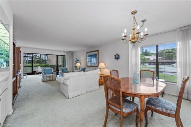 Dining room with light colored carpet, a chandelie