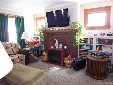 Living Room. The living room has a woddburning fireplace and built in book shelves on both sides of it.