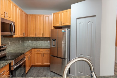Kitchen featuring stainless steel appliances, dark