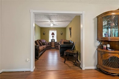 Living room featuring baseboards, a textured ceili