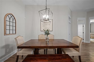 Dining area with a chandelier, dark wood-style flo