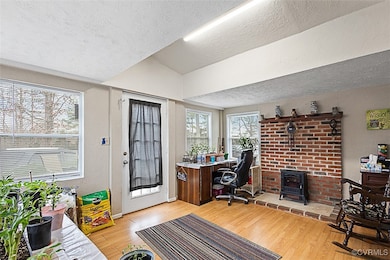Office area with a textured ceiling, light wood fi