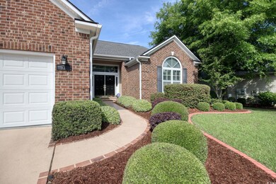 View of exterior entry with a lawn, brick siding, 