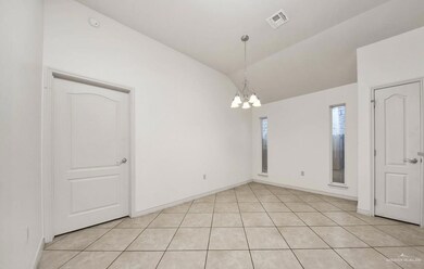 Unfurnished room with a notable chandelier, vaulted ceiling, and light tile flooring