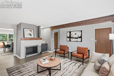 Virtually Staged - Living area with wood finished floors, a textured ceiling, and a tile fireplace