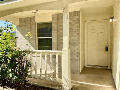 Property entrance featuring brick siding and a porch