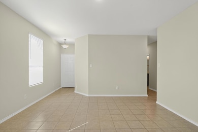 Empty room with light tile patterned floors and baseboards