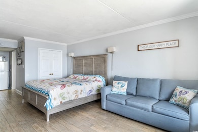 Bedroom featuring crown molding, hardwood / wood-s