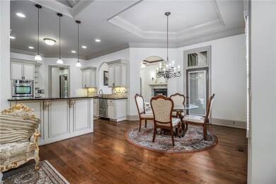 Dining space with dark wood-style floors, arched w